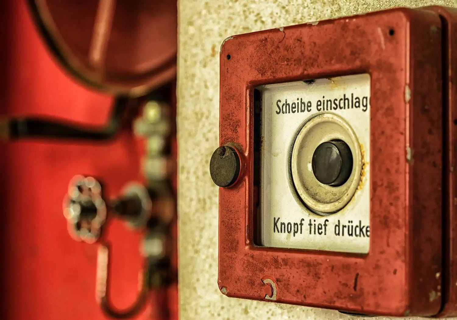 Rote, quadratische, deutsch beschriftete Notruftaste.